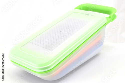 Photos Side View of Multifunction Kitchen Grater Container, Side angle of a multifunction vegetable grater container with colorful storage layers isolated on white background for kitchen product catalogs
