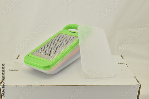 Foto Side View of Multifunction Kitchen Grater Container, Side angle of a multifunction vegetable grater container with colorful storage layers isolated on white background for kitchen product catalogs