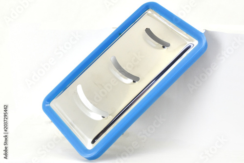 Fotografie Blue Compact Kitchen Slicer with Stainless Blades, Compact blue kitchen slicer with stainless steel cutting blades isolated on white background for cooking and household equipment concepts