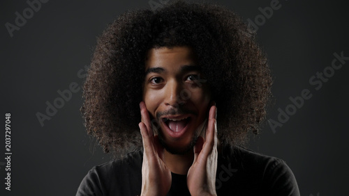 Quadro su tela Young man with afro hair showing expression of surprise and astonishment