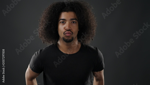 Принти на полотні Young black man forming pouting lips expression on a dark background