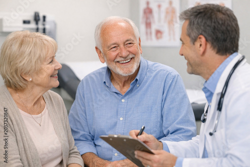 Image of a doctor and two elderly patients engaged in conversation.