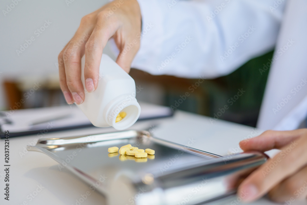 Fototapeta premium Pharmacist preparing medication counting pills for customer service in pharmacy
