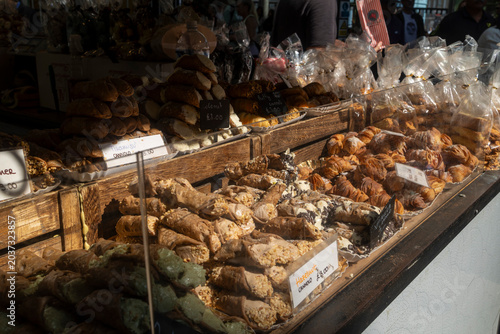London, UK, A traditional market display counter filled with an abundance of fresh Italian pastries including various flavored cannoli and sfogliatella. 