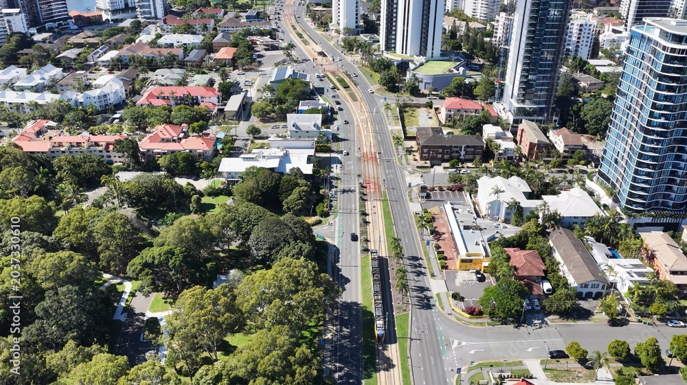 Fototapeta premium Aerial View of a Modern Light Rail Tram Moving Through Gold Coast