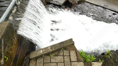 Clear water flows through irrigation canals in a village, providing clean water for rice fields. It is crucial for sustainable agriculture and efficient water management.