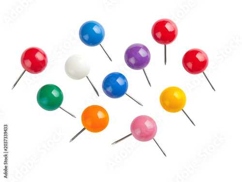Colorful thumbtacks scattered on a white background, ready for use in office or craft projects