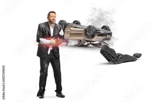 Man with abdomen injury standing by car collision