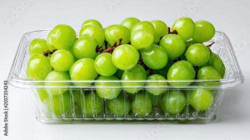 Fresh-Cut Fruit Fresh green grapes packed in a clear plastic container ready for sale or consumption.