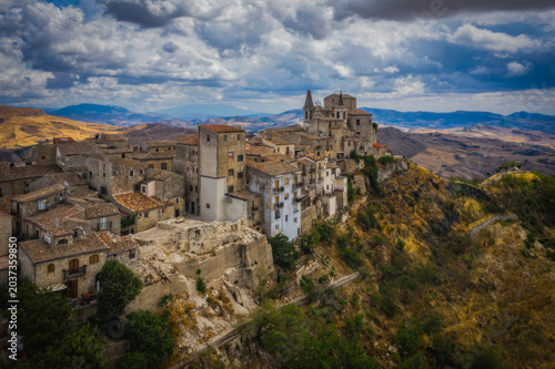 Aerial drone view of town Petralia Soprana, Sicily, Italy. An avenue of trees leading to the hilltop in the Madonie Mountains. August 2024