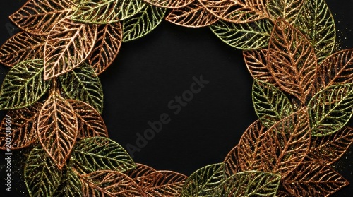 Elegant wreath of golden leaves on a dark background, perfect for decoration.