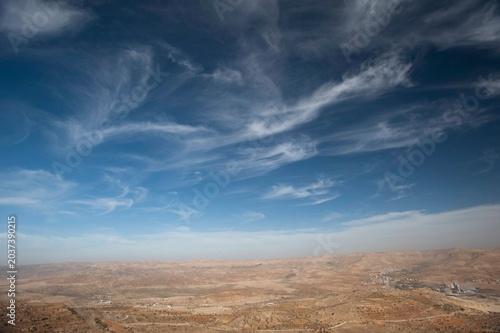 Tableau sur toile Scenic natural landscape of rugged, rocky mountains and valleys under a vast blue sky covered with dramatic white clouds in Mardin