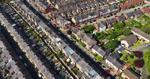 Aerial drone footage of rows of terraced housing and suburban streets in the city of York North Yorkshire England showing brick homes gardens roads and residential urban development in the summer