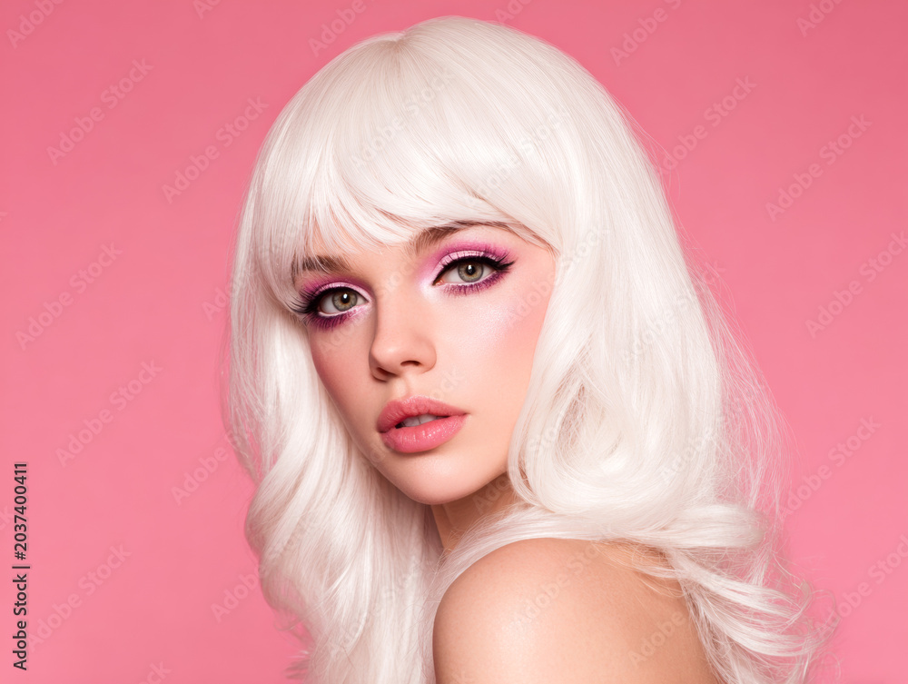 Fototapeta premium Glamorous woman with white curly hair and pink makeup on pink background