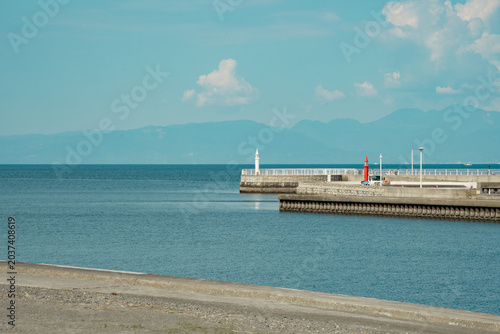 Foto Scenic coastal harbor with pier and lighthouses in Japan