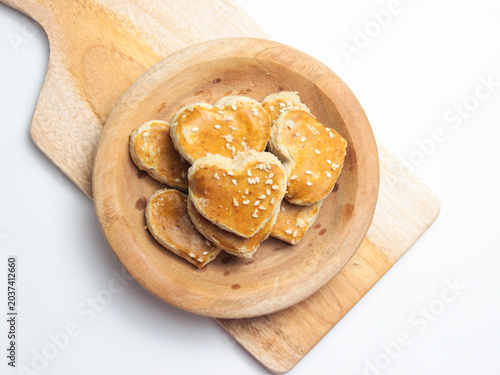 Photos Close up of peanut cookies with sesame seeds topping that shape of the heart, to