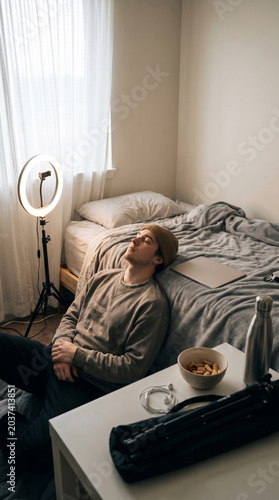 Vertical creator break scene with ring light tablet and unmade bed