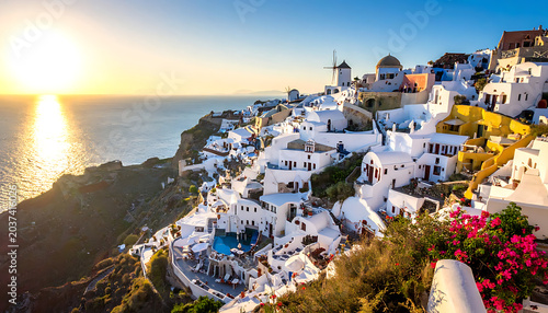 iconic white village clinging to a cliffside overlooking the sea at sunset, Santorini Greece, travel destination