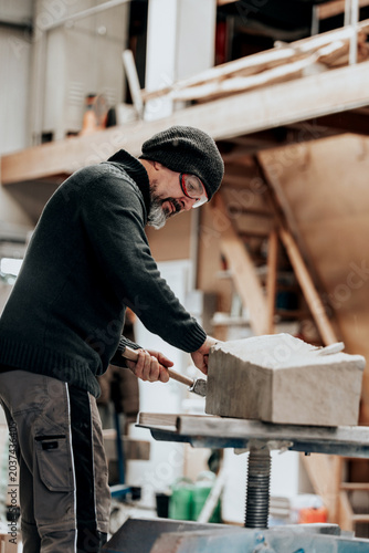 stone mason is working with different tools like chisel, mallet or hammer