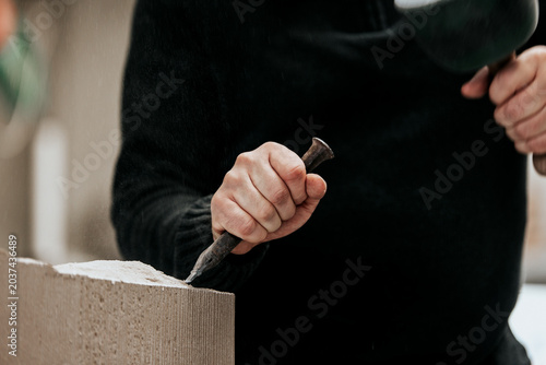 stone mason is working with different tools like chisel, mallet or hammer