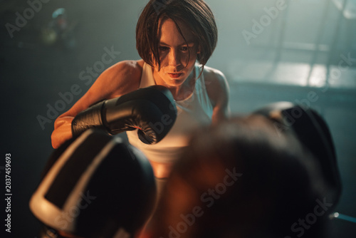 Fotografija Female boxer training in ring, battling for victory, showing grit and determinat