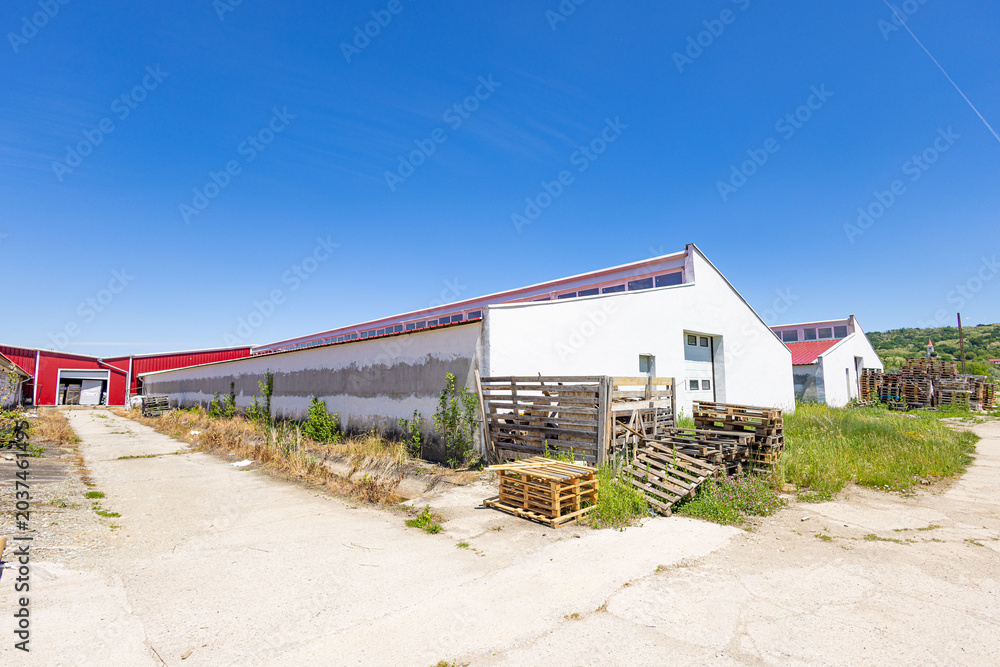 Naklejka premium Industrial warehouse exterior with stacked wooden pallets
