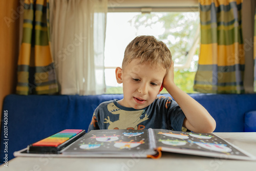 Preschooler doing exercises in a camper van in summer. 