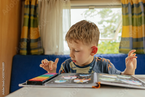 Preschooler doing exercises in a camper van in summer. 