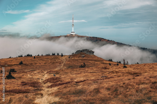 Bild auf Leinwand Distant view of Praded transmitter tower rising above low clouds