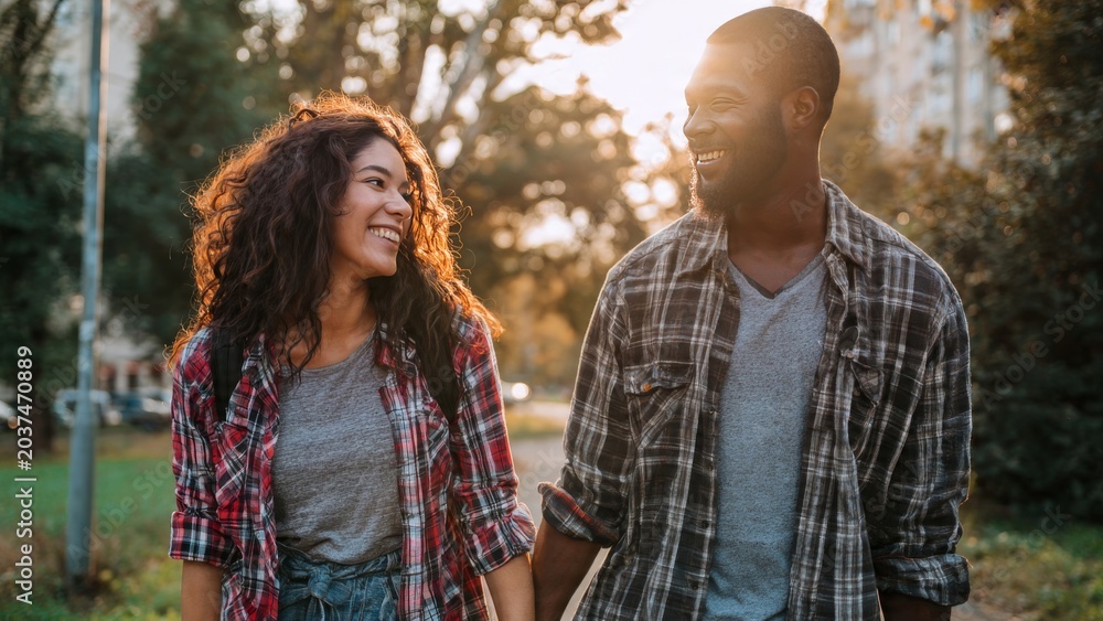 Obraz premium Happy young couple walking in park during sunset