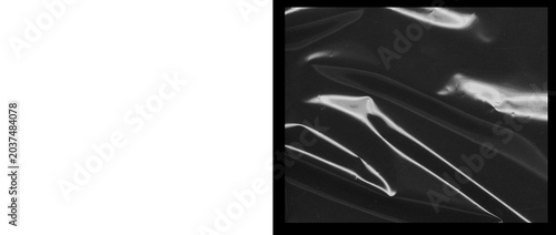 Fotografie Abstract black plastic texture with glossy highlights, wrinkled dark polyethylen