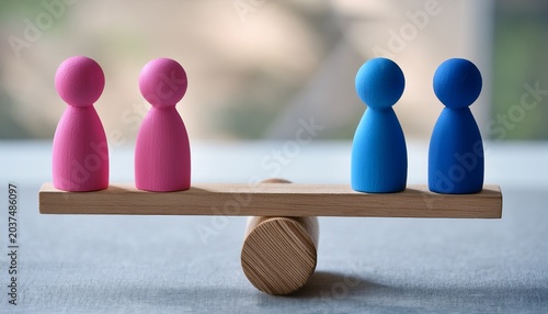 pink and blue figurines on wooden seesaw symbolizing gender equality and balance