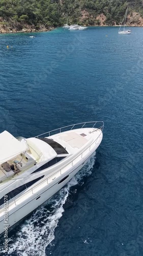Luxury Yacht Cruising Through Azure Waters Near a Lush Green Coastline