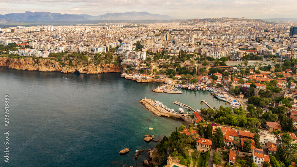 Naklejka premium drone aerial of Antalya marina harbor bay and the steep coastal cliffs. Beautiful marine landscape and Mediterranean resort town lifestyle scenery in Turkey