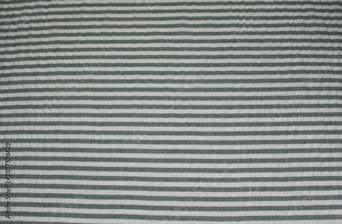 Texture of crumpled grey horizontal striped line like cloth. Close up of wrinkled grey and white striped fabric background.	