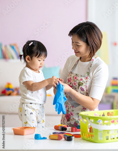 The mother helps her child put on protective gloves for a messy craft, hands visible.