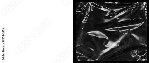 Cuadro en lienzo Crumpled black plastic texture with glossy highlights, wrinkled dark cellophane