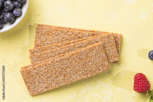 Fresh crunchy rye crispbreads with different toppings on green table, top view