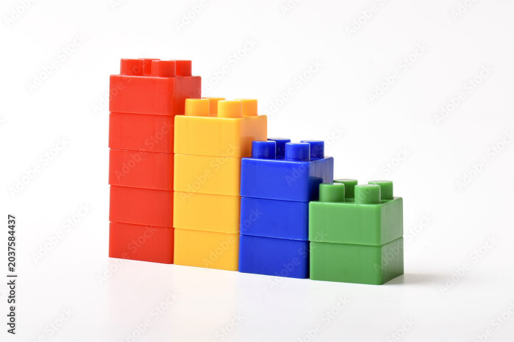 Fototapeta premium Four colorful toy blocks. Colorful Building Blocks Stacked in Ascending or falling Bar Graph Formation on White Background.