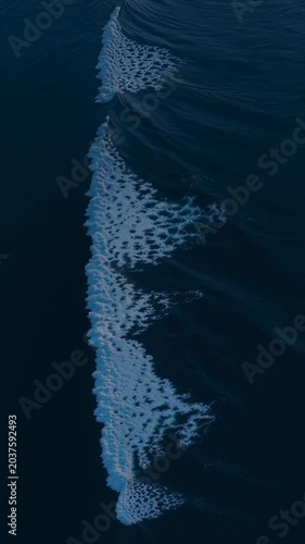 Serene Aerial View of Calm Ocean Waves Gently Meeting Shoreline Under Soft Sunset Light