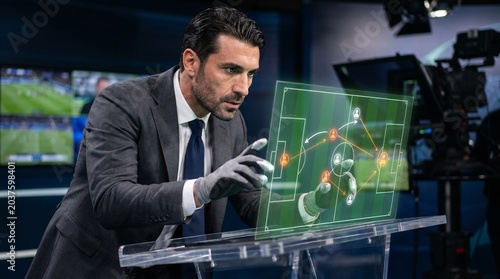 Sports analyst studying futuristic holographic soccer game strategy
