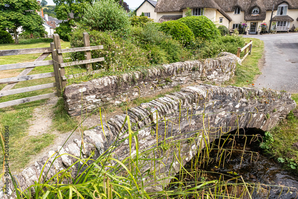 Obraz premium Exmoor National Park - The medieval stone packhorse bridge over the Winn Brook in the village of Winsford, Somerset, England UK