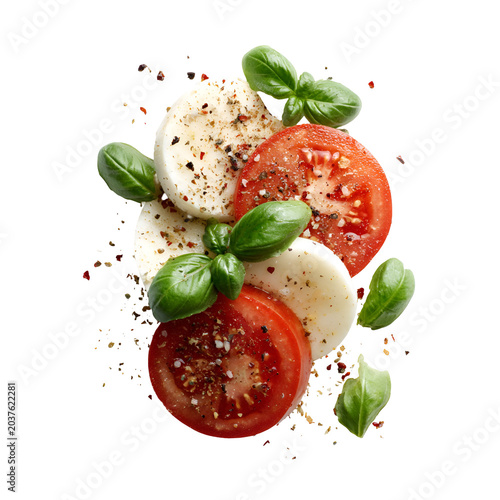 Fresh Caprese salad with tomatoes, mozzarella and basil on white plate
