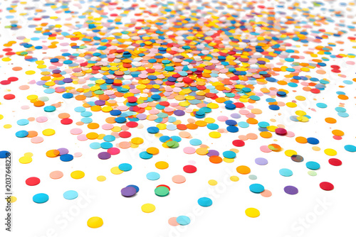 Brightly colored confetti sprinkles on a white surface, festive birthday party anniversary celebration background, confectionery sweets layout