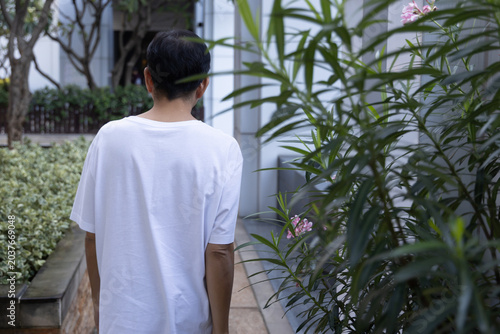 Relaxed happy carefree middle age old Asian man taking evening walk, breathing the clean, unpolluted air in green park, wellness concept image of good summer, summer wellness, rear view