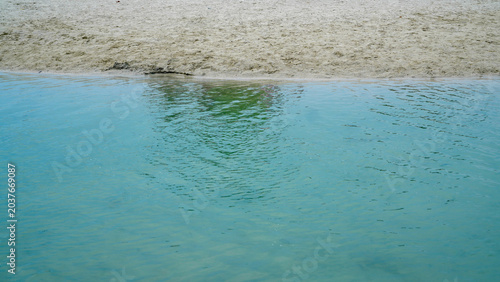 Tableau sur toile A tranquil shoreline scene featuring crystal-clear turquoise water gently meetin