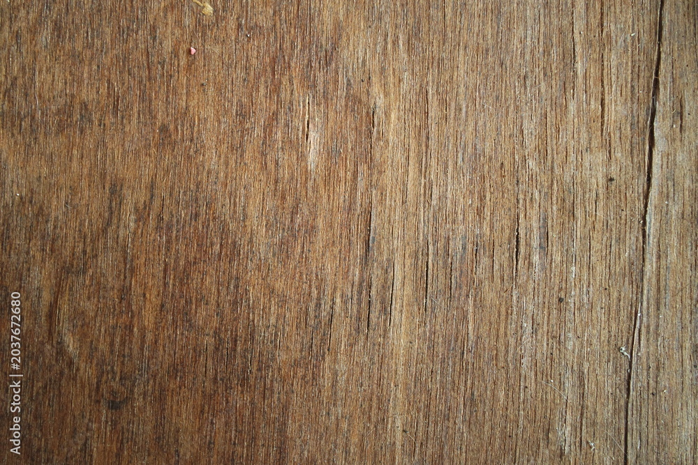Obraz premium Close-up of a dark brown weathered natural wood grain texture surface background for rustic design layouts.