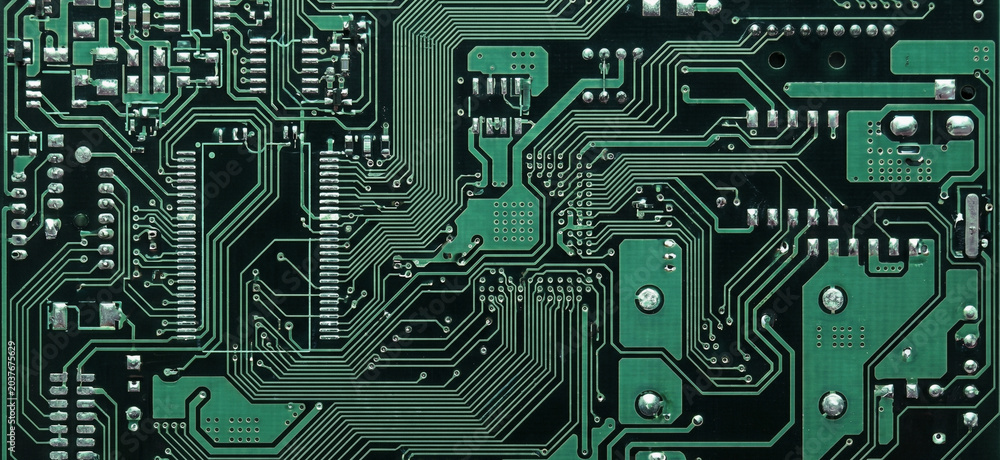 Fototapeta premium Close-up of a green circuit board with intricate pathways and components. Ideal for technology, electronics, or circuit design themes.