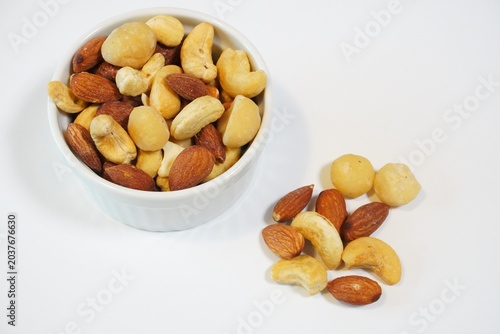 Mixed nuts in white bowl on white background