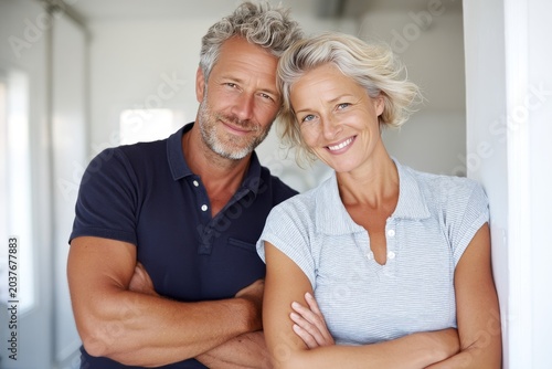 Portrait of a satisfied couple in their 50s donning a classy polo shirt in minimalist or empty room background